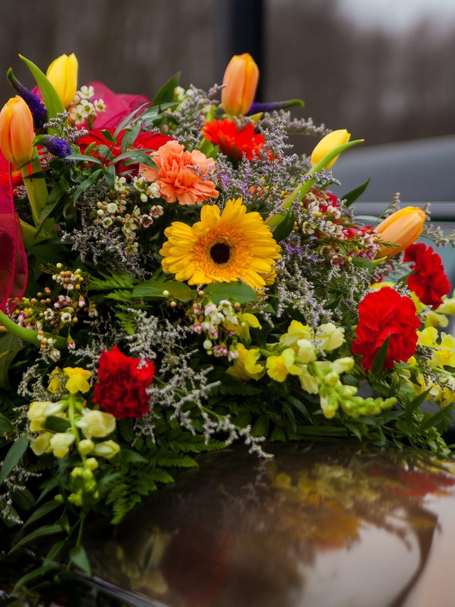 funeral-casket-and-flowers-next-to-hearse