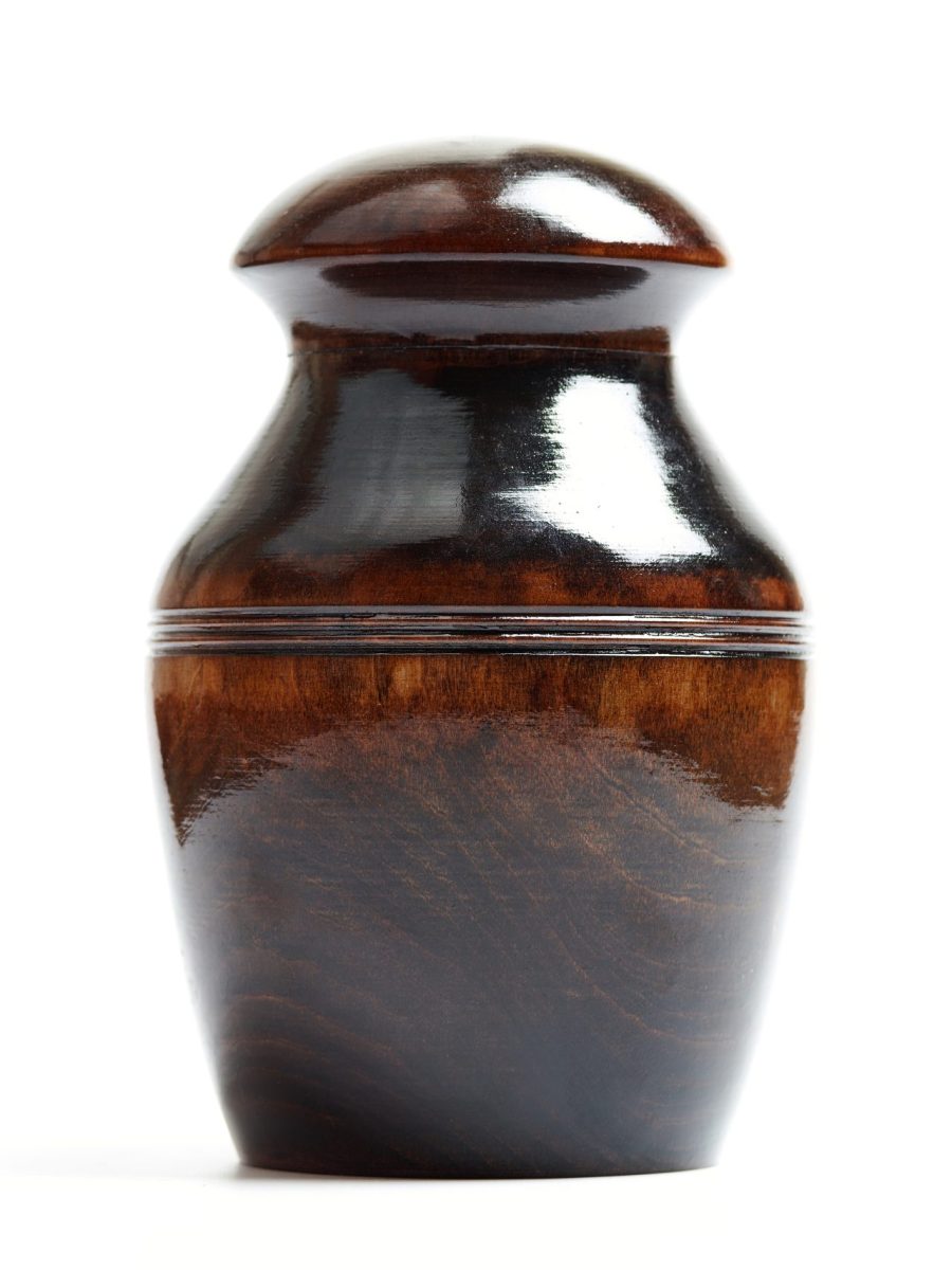 Wooden funeral urn of pet, isolated white background. Burial cinerary urn close up.
