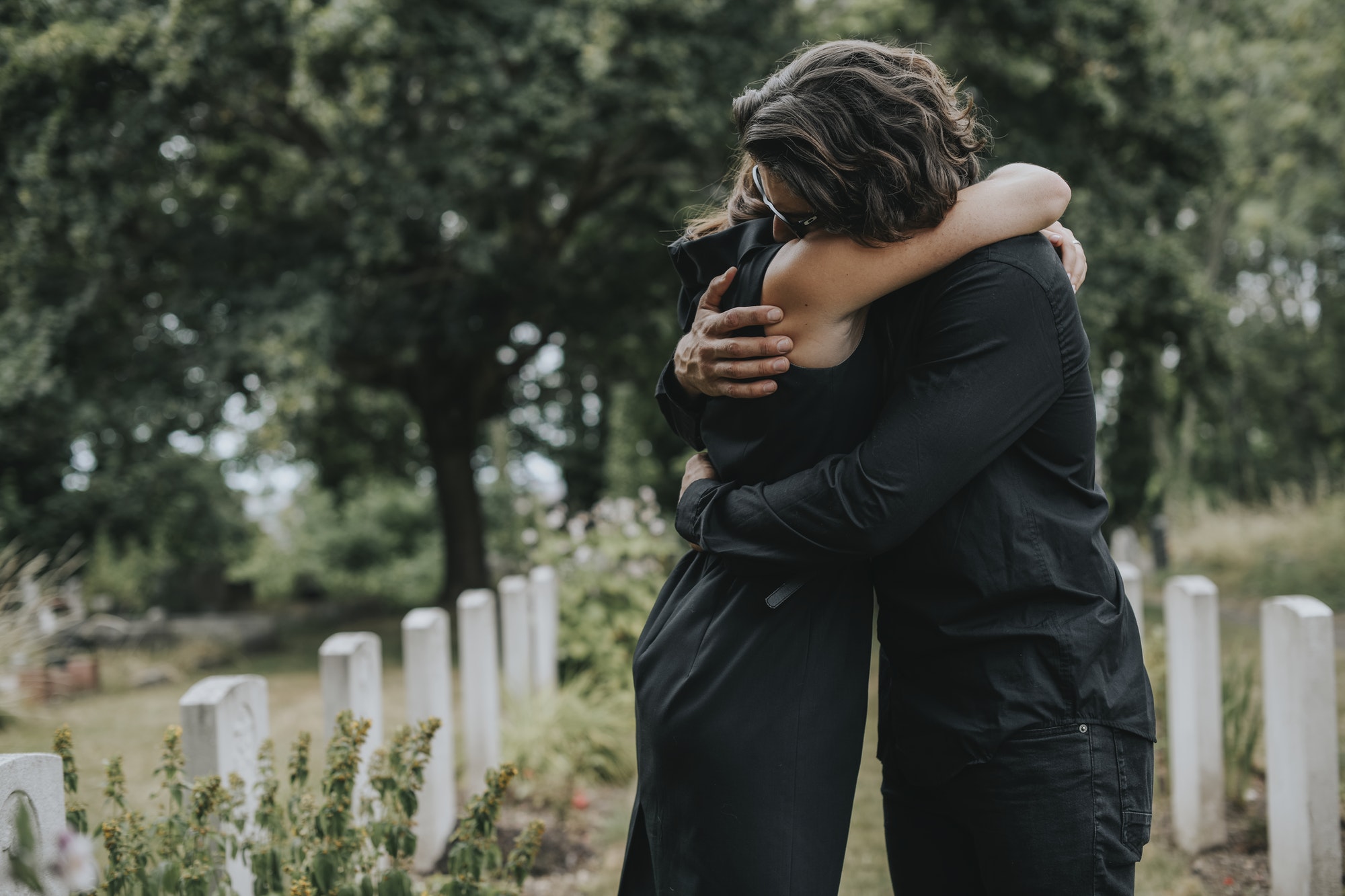 husband-trying-to-comfort-his-wife-at-a-graveyard.jpg