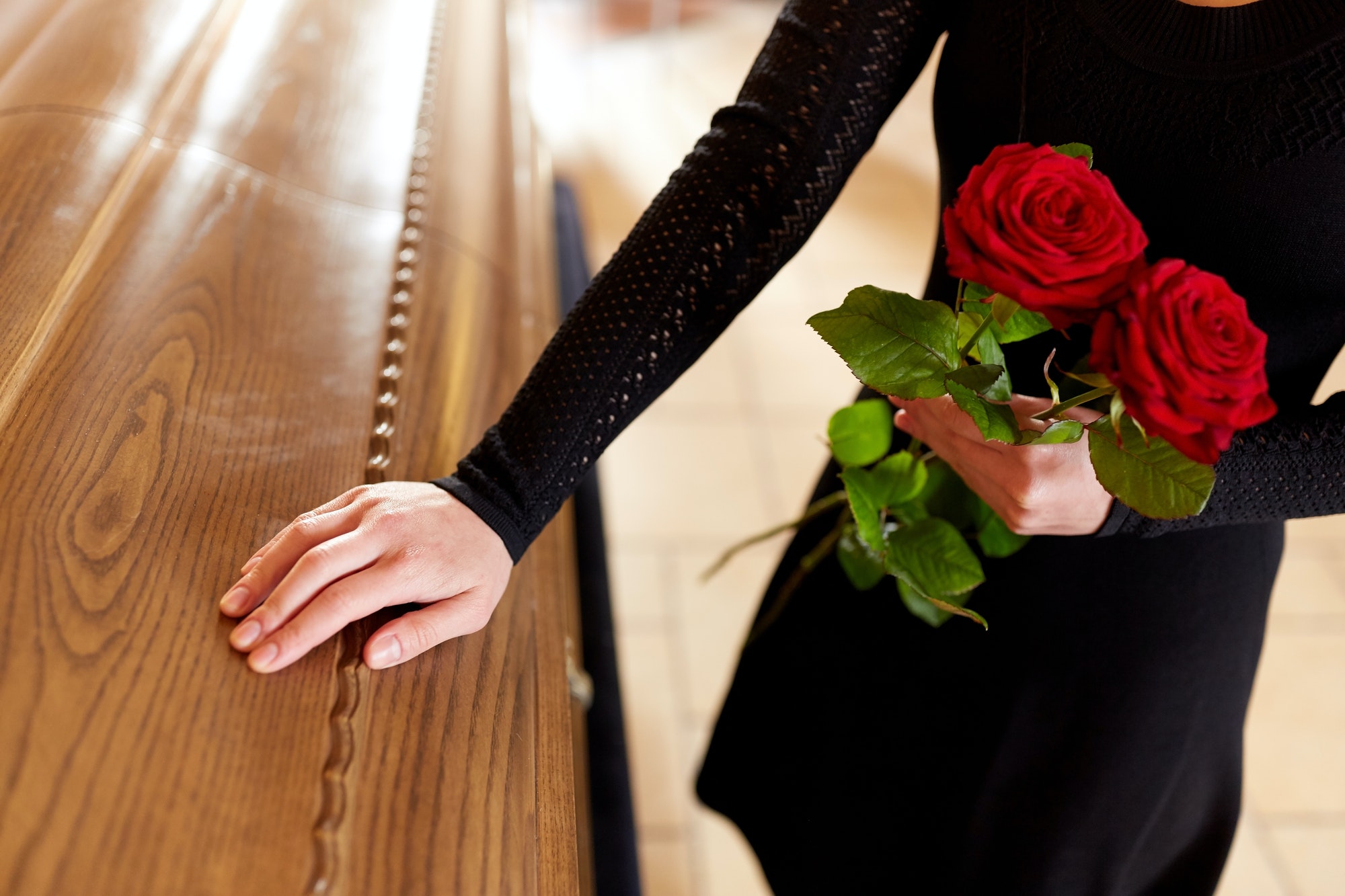 woman-with-red-roses-and-coffin-at-funeral-1.jpg