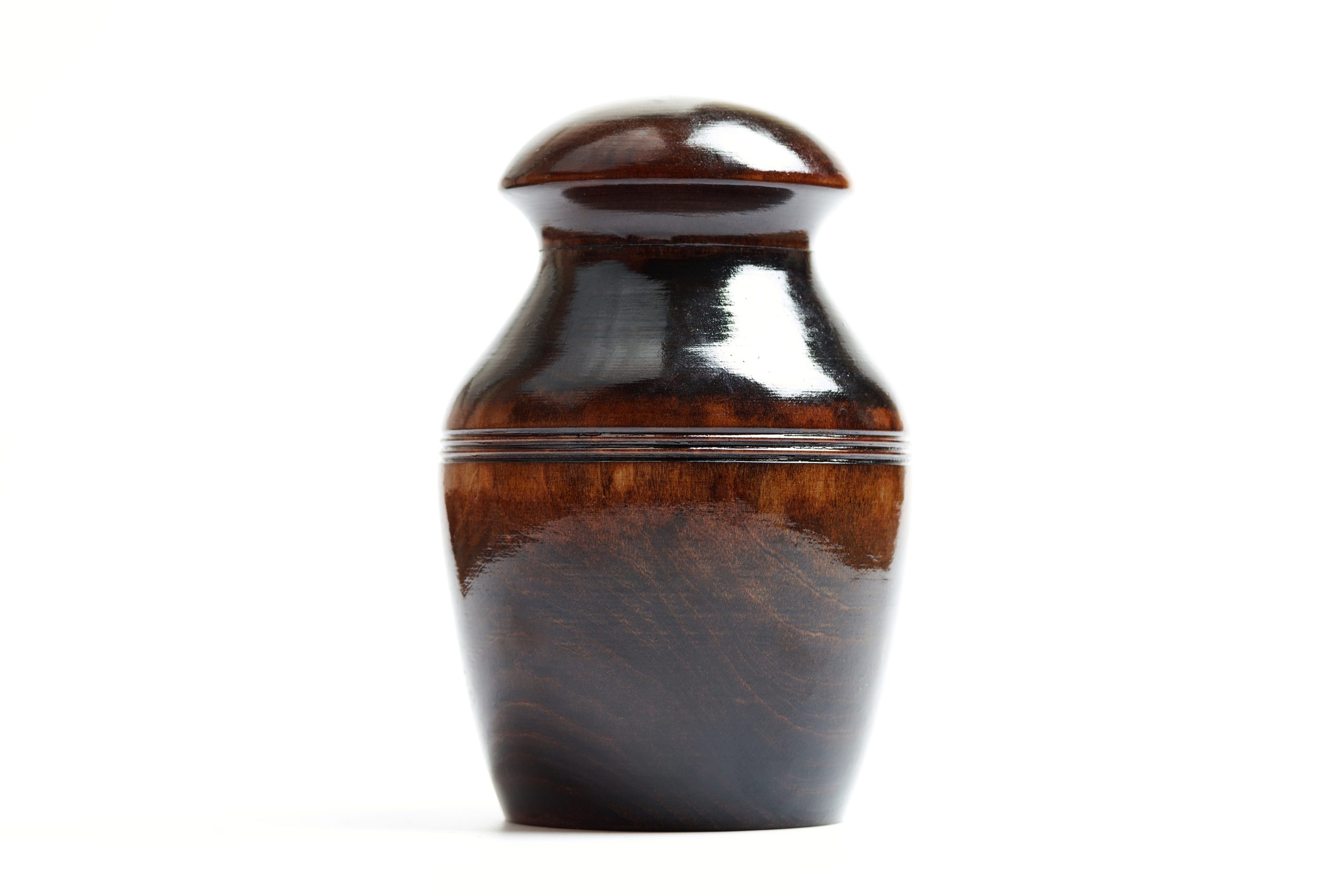 Wooden funeral urn of pet, isolated white background. Burial cinerary urn close up.